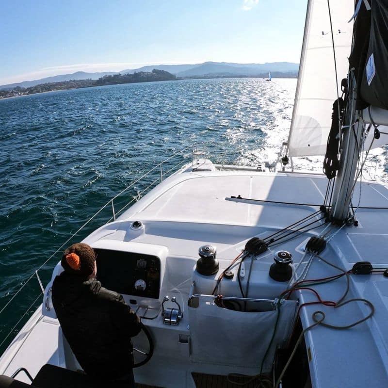 Alumno de prácticas de perfeccionamiento de catamarán navegando por la ría de Vigo Galicia