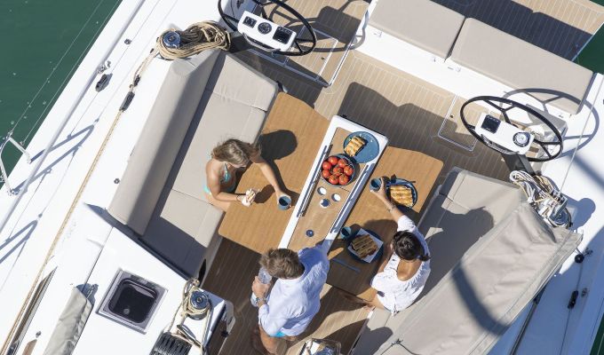 Draufsicht auf eine Familie, die eine Mahlzeit im Cockpit einer Dufour 430 Grand Large Segelyacht genießt.